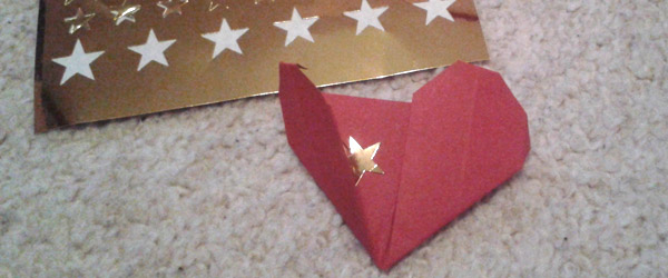Origami heart with gold star sticker inside.